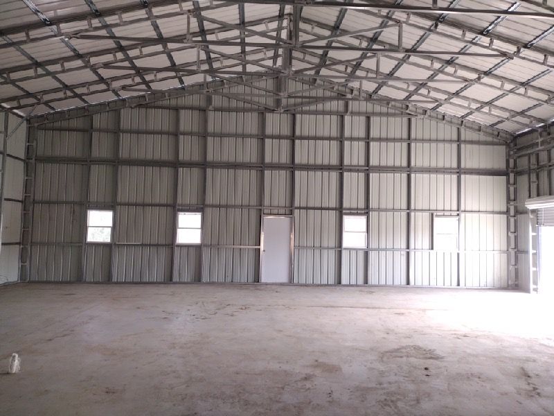 the inside of a garage with a metal frame and white walls .