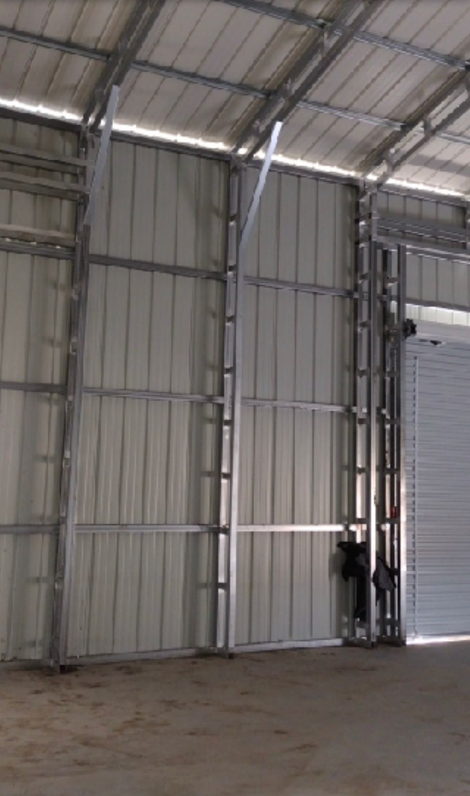 the inside of a garage with a metal frame and white walls .