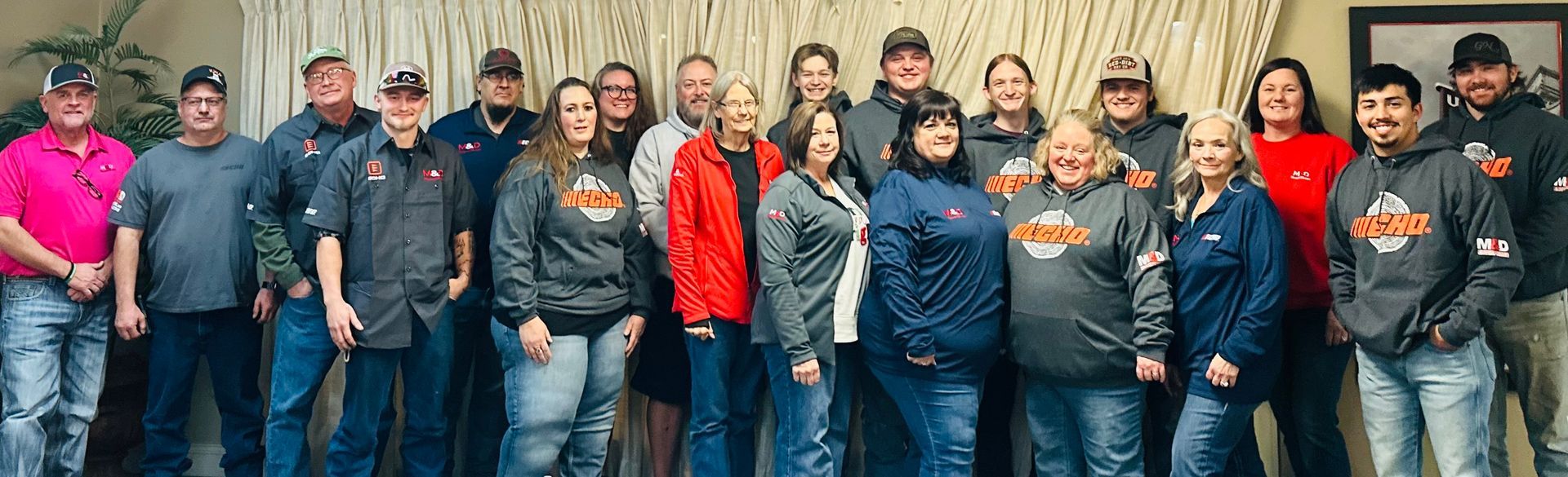 A group of people are posing for a picture together in a room.