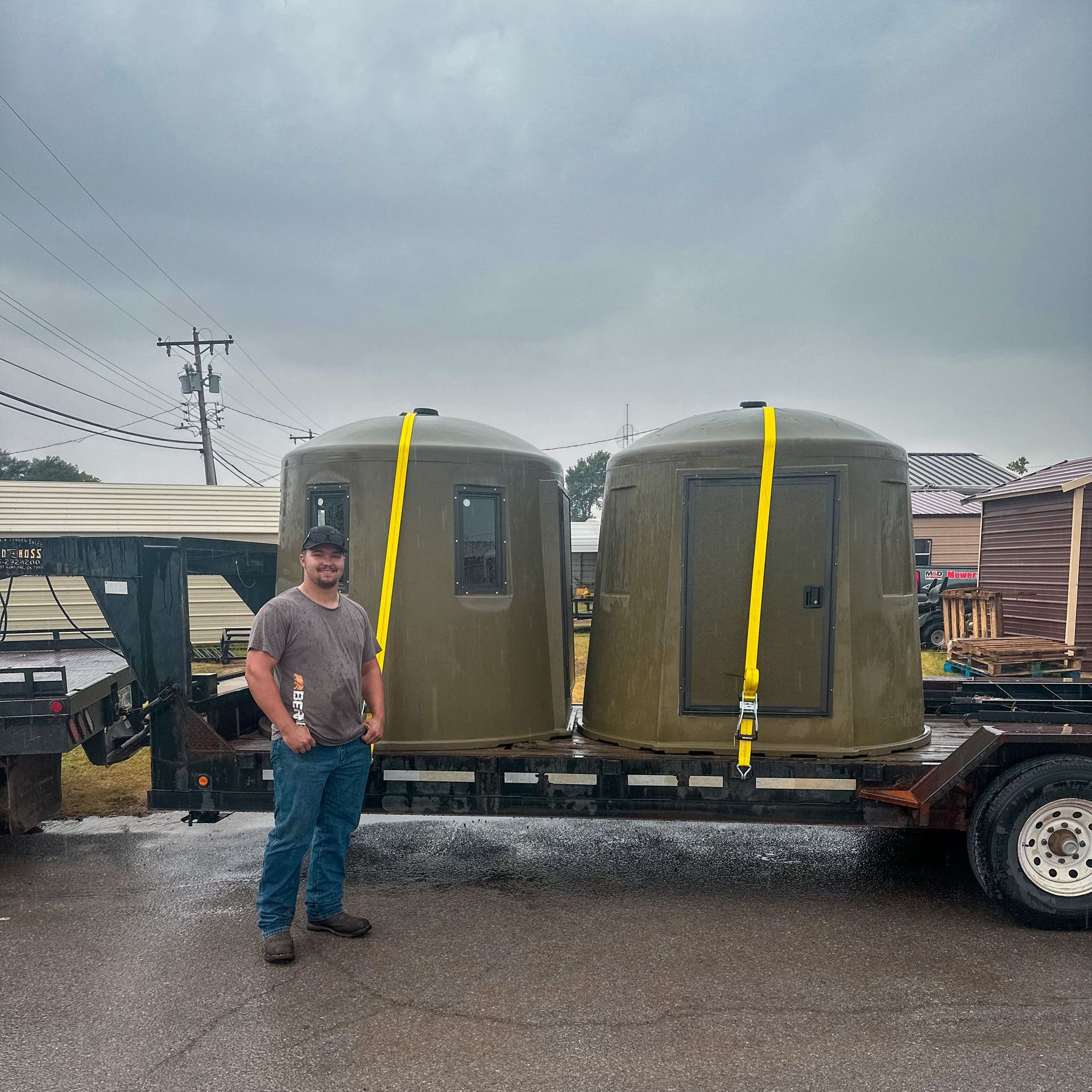 a man is standing in front of a trailer with two phantom blinds on it 