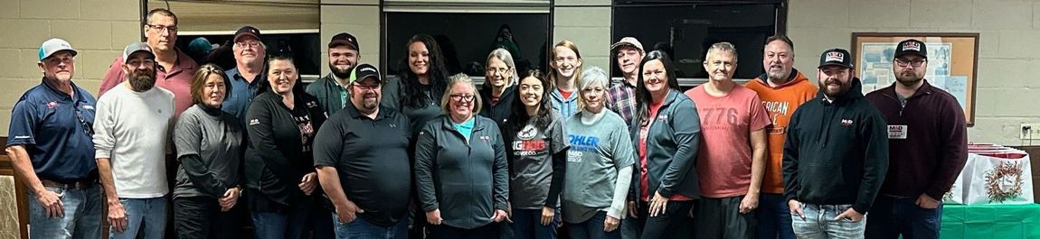 A group of people are posing for a picture together in a room.