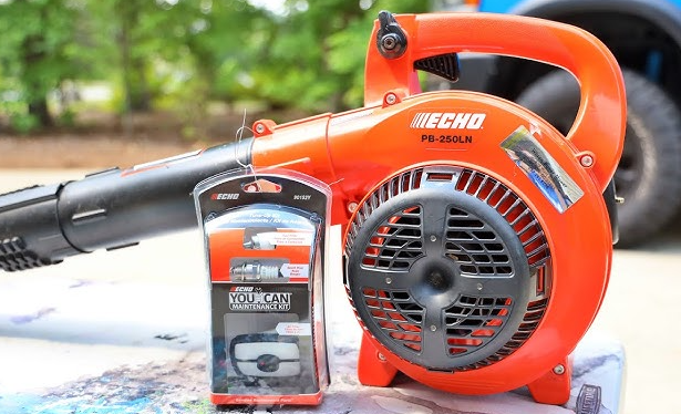 A blower is sitting on a table next to a battery.