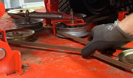 A person is working on a lawn mower belt.