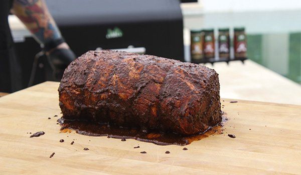 A large piece of meat is sitting on top of a wooden cutting board.
