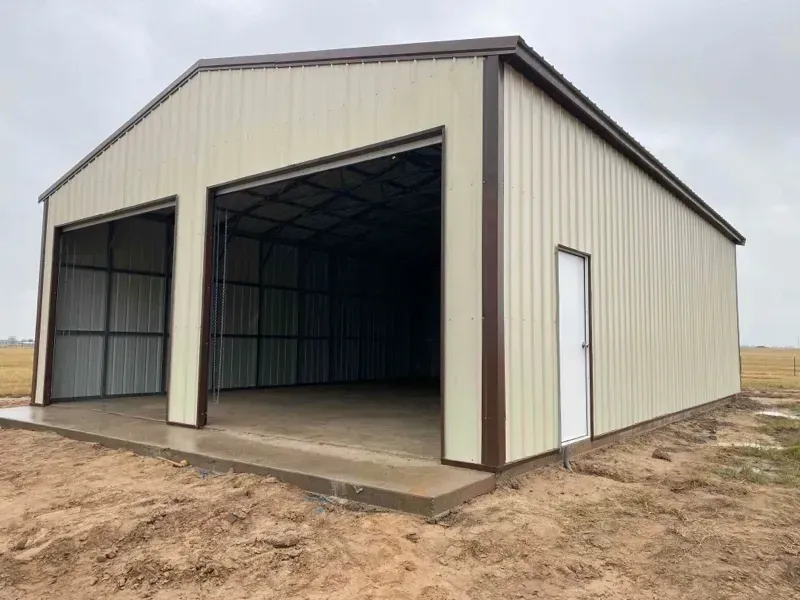 Open beige metal storage building with two large garage bays and a side door on a dirt lot