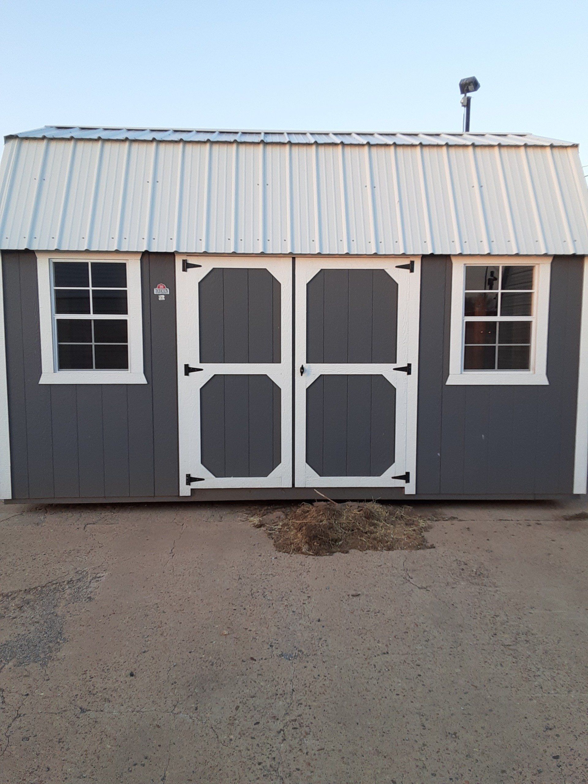 A gray and white side Lofted barn with a white roof