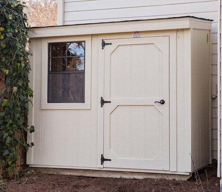 Un cobertizo blanco con una ventana al costado de una casa