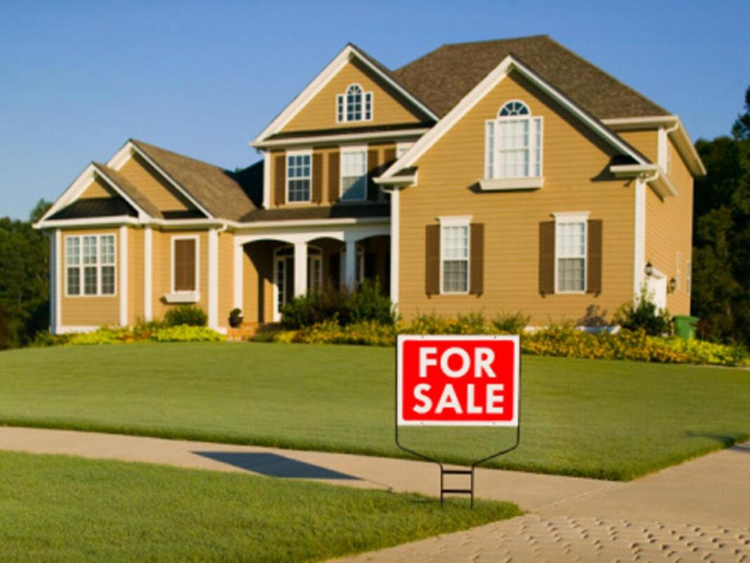 A house with a for sale sign in front of it