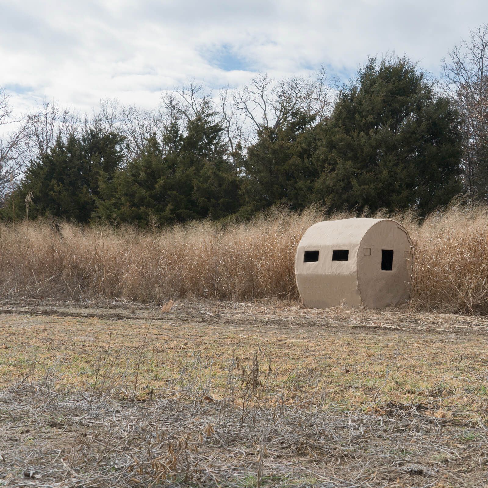 a redneck blind  in the middle of a field 