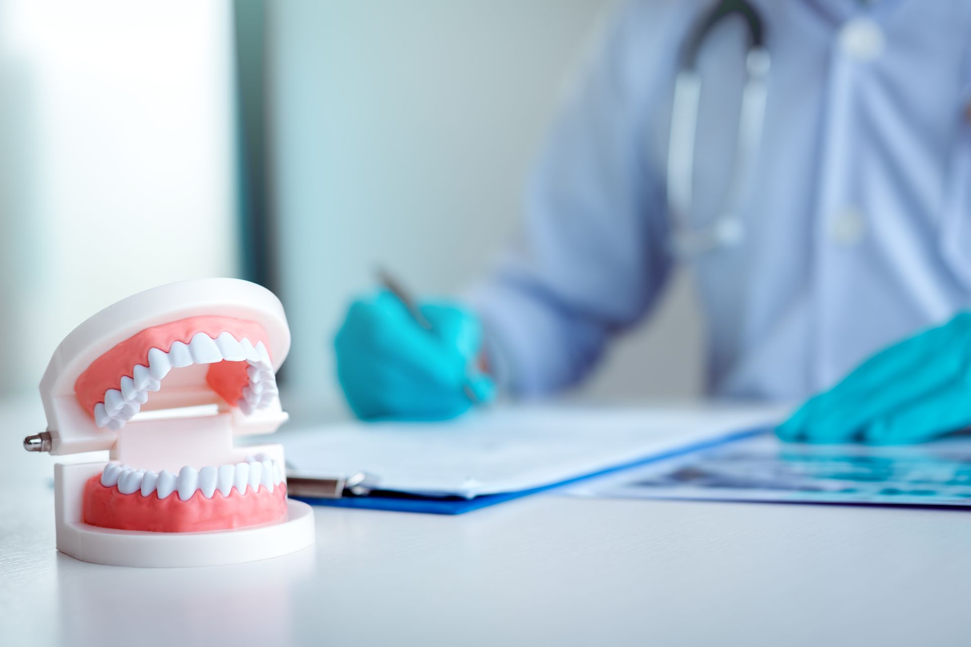 Dentist writing a summary report at a desk in a laboratory setting.