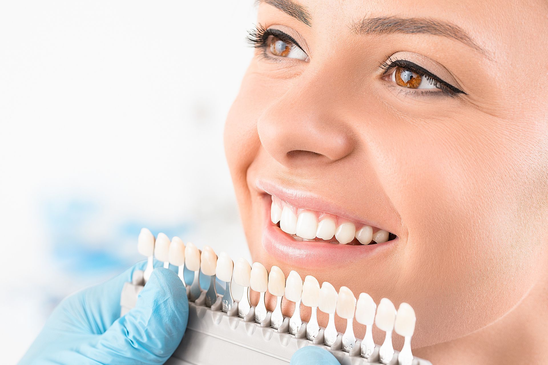 Beautiful young woman smiling, showcasing natural white teeth with dental implants.