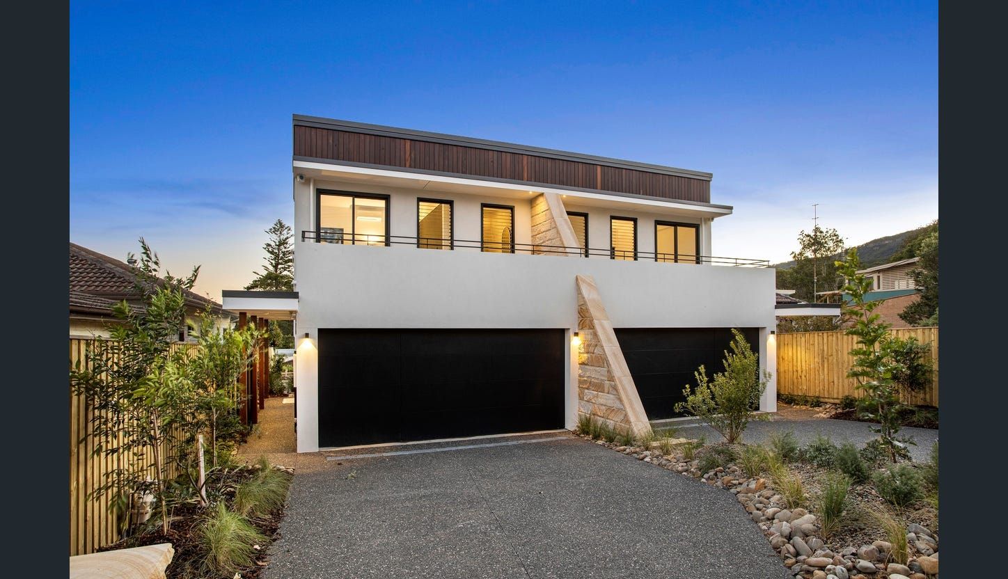 A Large House With a Lot of Windows is Surrounded by Trees — LG Constructions in Thirroul, NSW