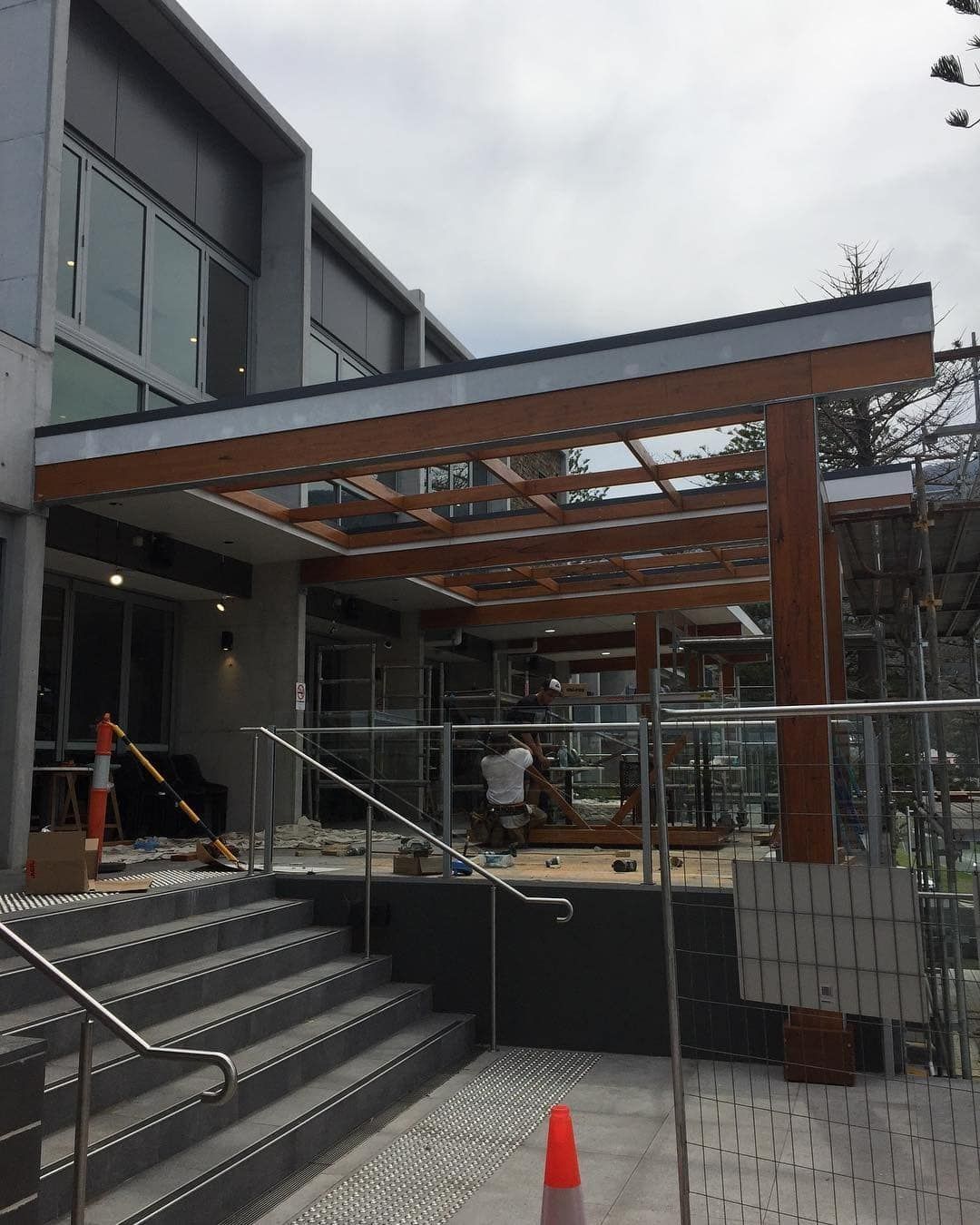 A Wooden Pergola is Being Built on the Side of a Building — LG Constructions in Thirroul, NSW