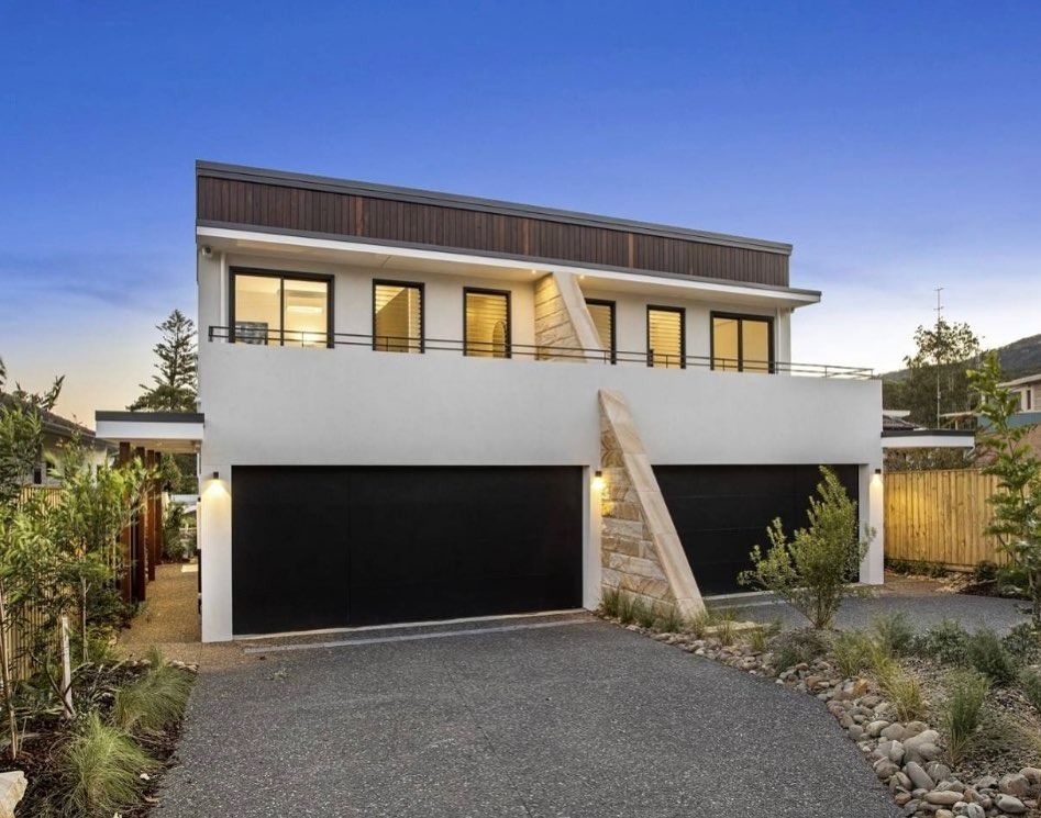 A  White Duplex House With Two Black Garage Doors — LG Constructions in Thirroul, NSW