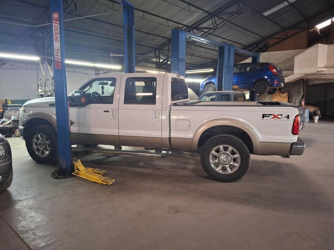 A white truck is parked on a lift in a garage.