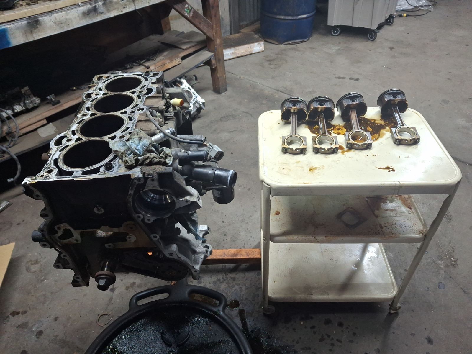 A cylinder block is sitting on top of a table with pistons on it