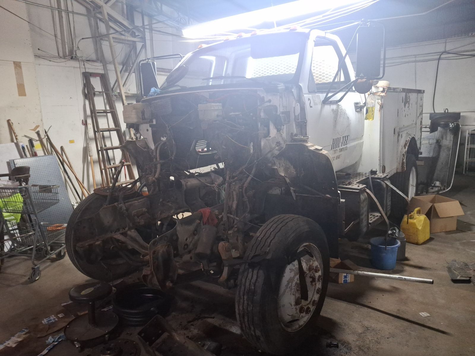 A truck is being dismantled in a garage.