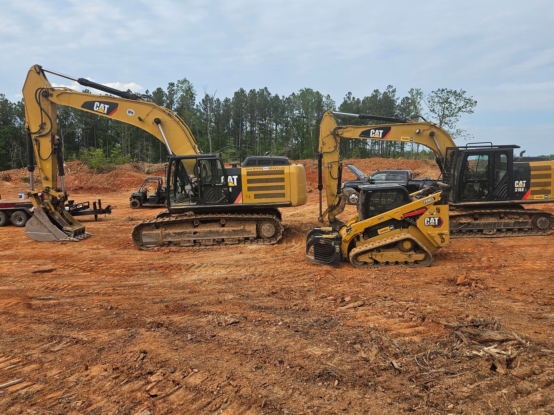 Yellow Caterpillar construction equipment on a muddy construction site.