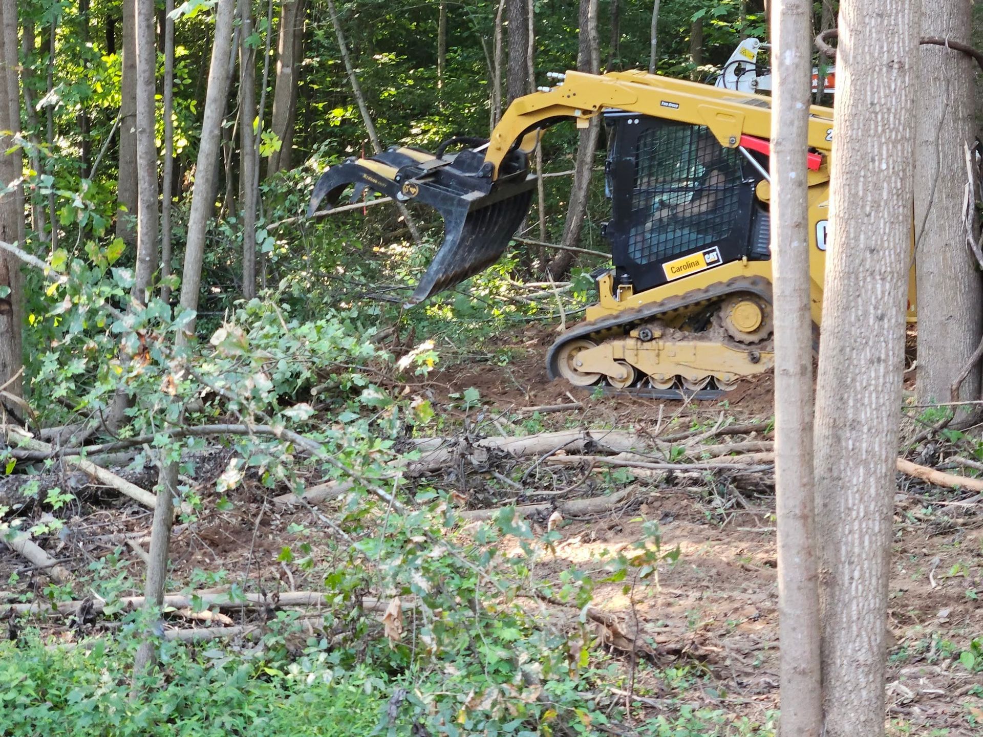 Three yellow CAT excavators on a construction site with a white truck in the background.