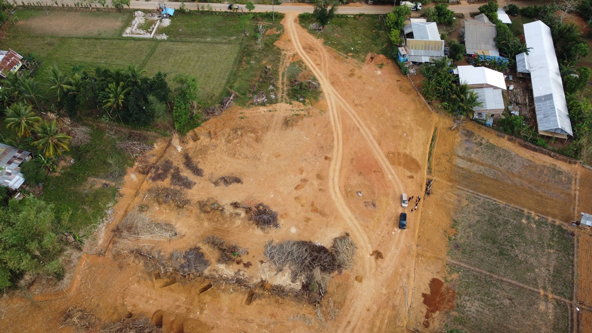 Three yellow CAT excavators on a construction site with a white truck in the background.