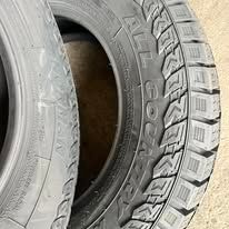 Two black car tires with deep treads, one partially visible.