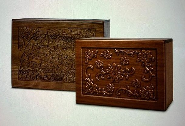 Hand-carved rosewood urn with rich brown wood grain on a white background
