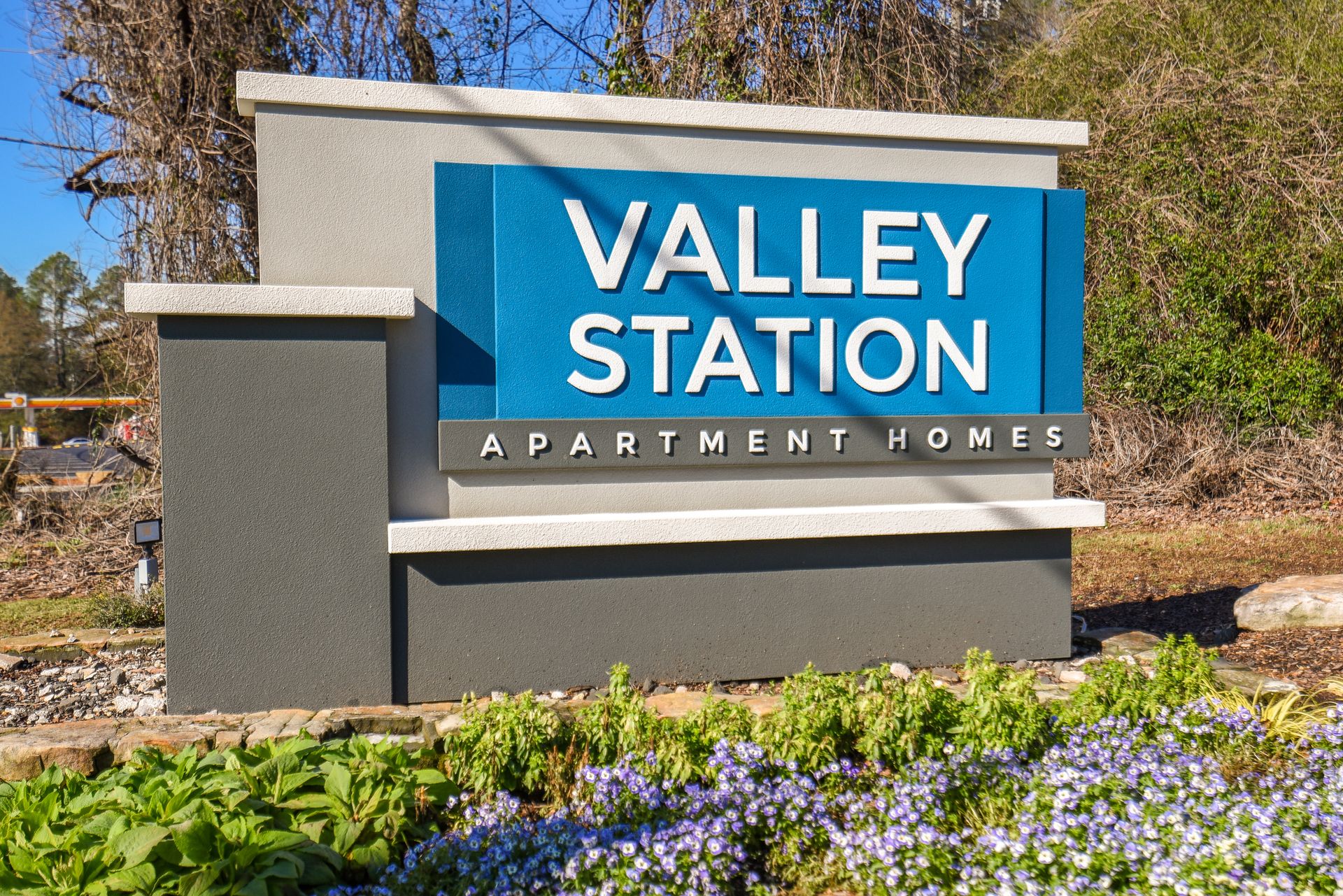 A modern gray and blue monument sign reads 