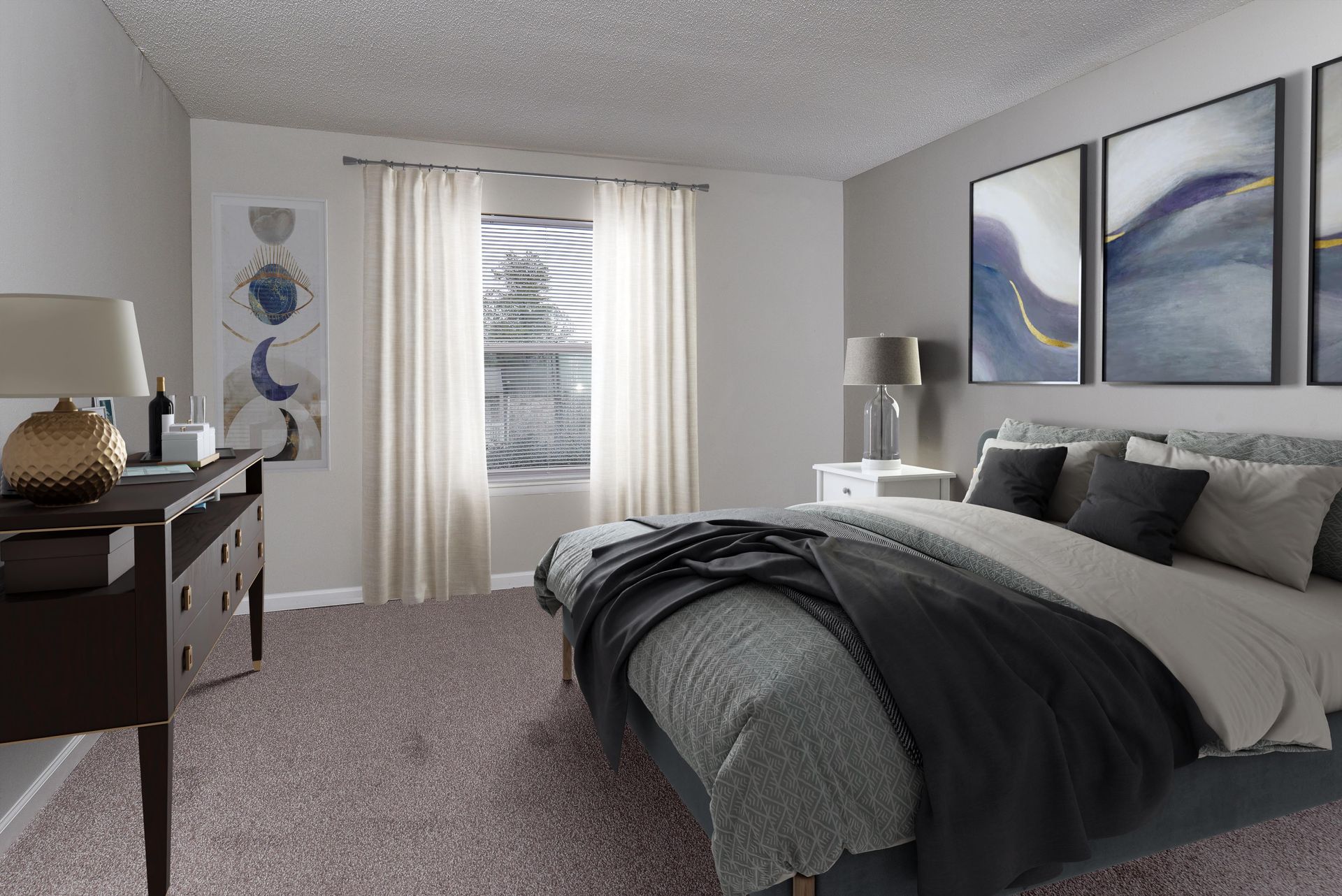 A modern bedroom featuring a gray bed with dark throw pillows, a dark dresser with a lamp, and neutral abstract wall art.