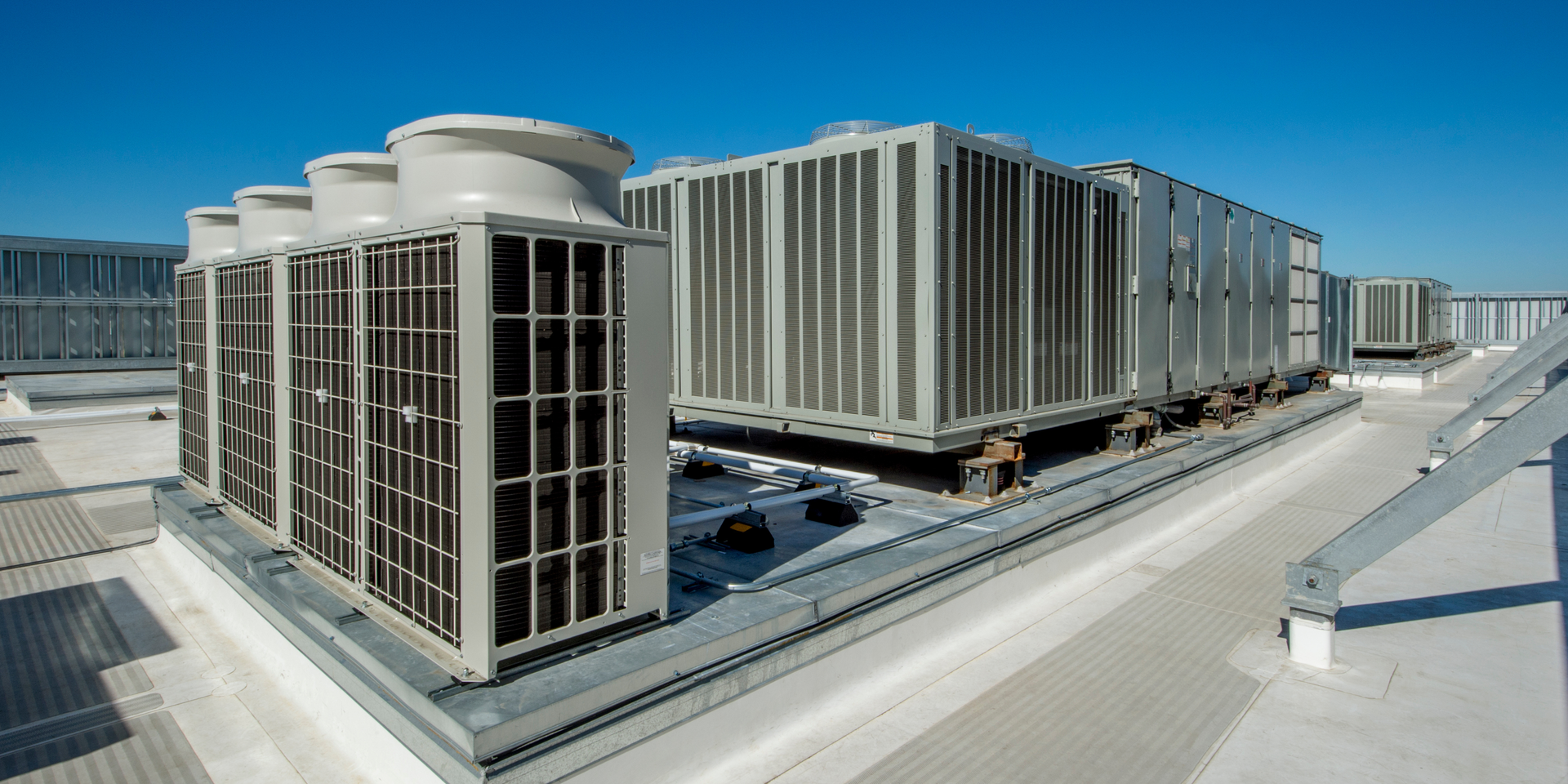 Commercial HVAC units on a flat roof under a clear blue sky.