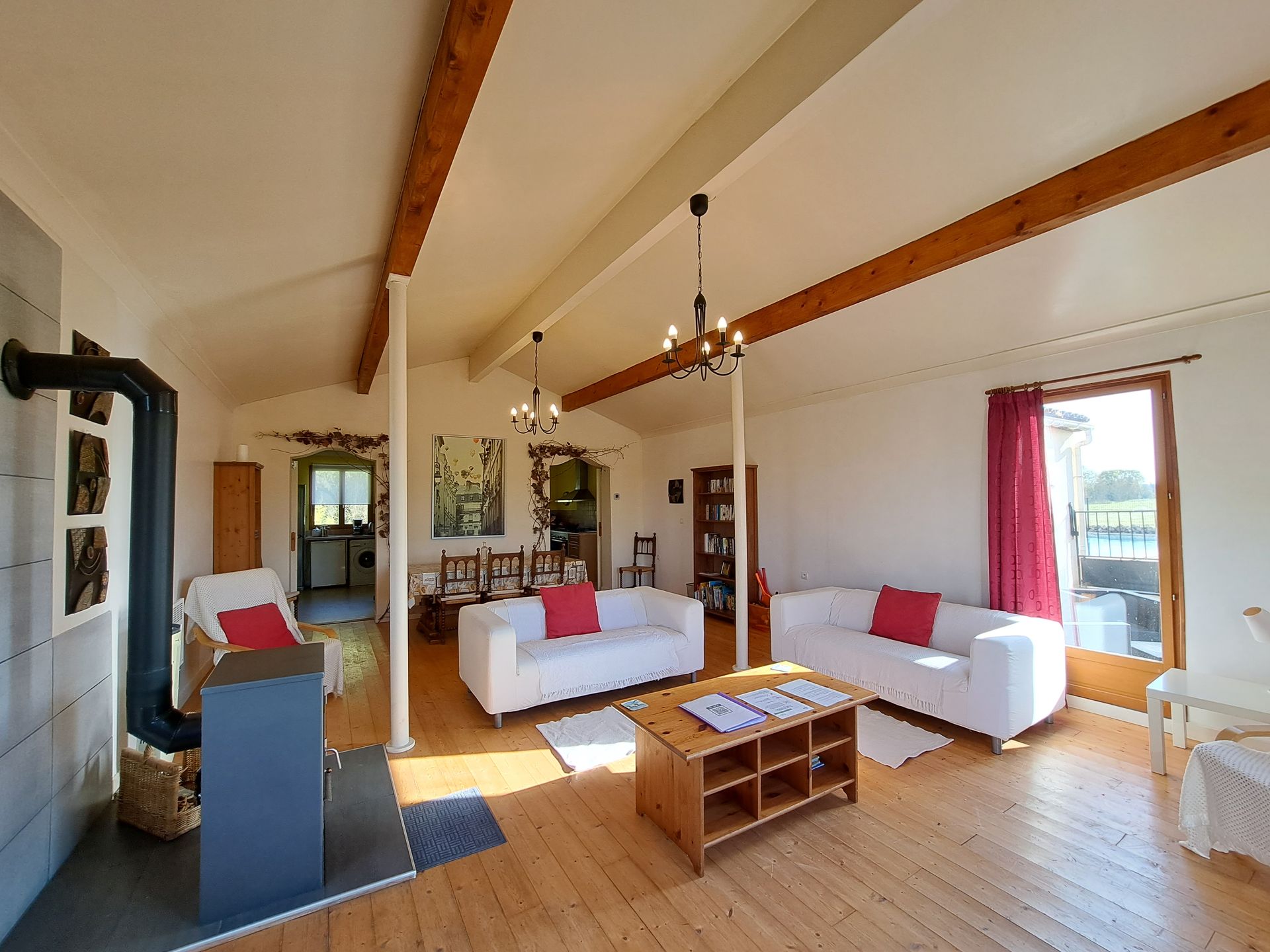 sitting room with vaulted ceiling and white ikea sofas with red cushions