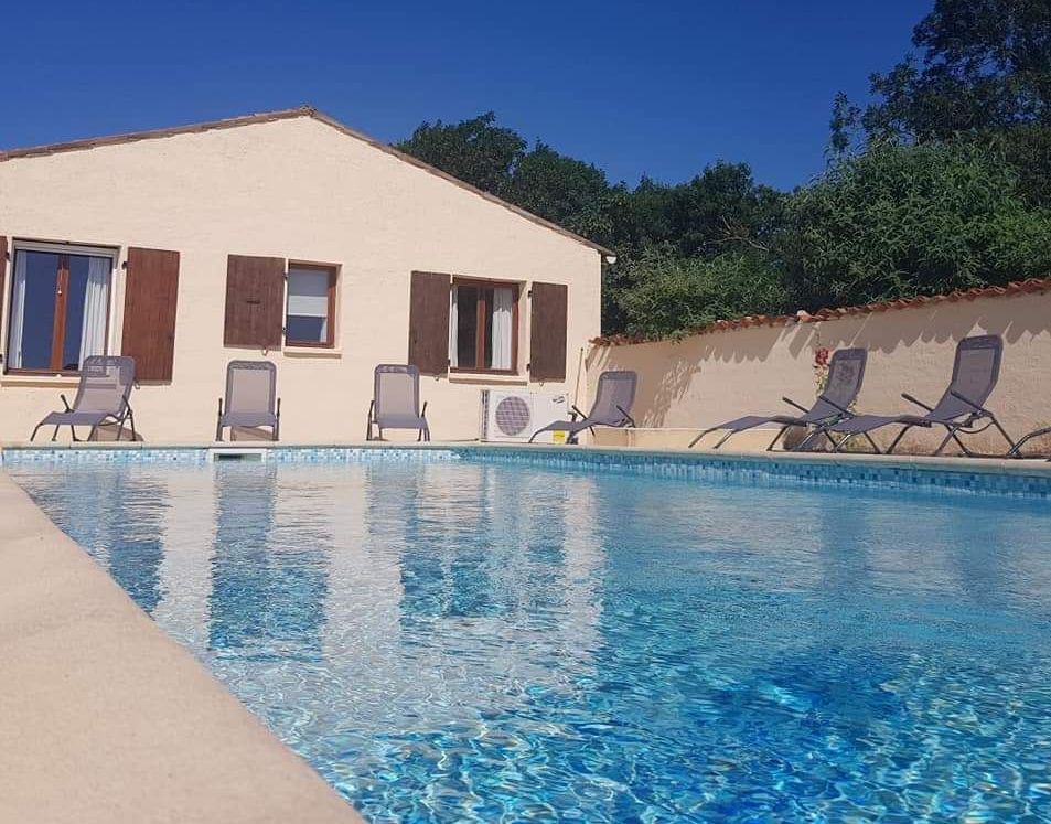 outdoor inground pool next to a single storey villa