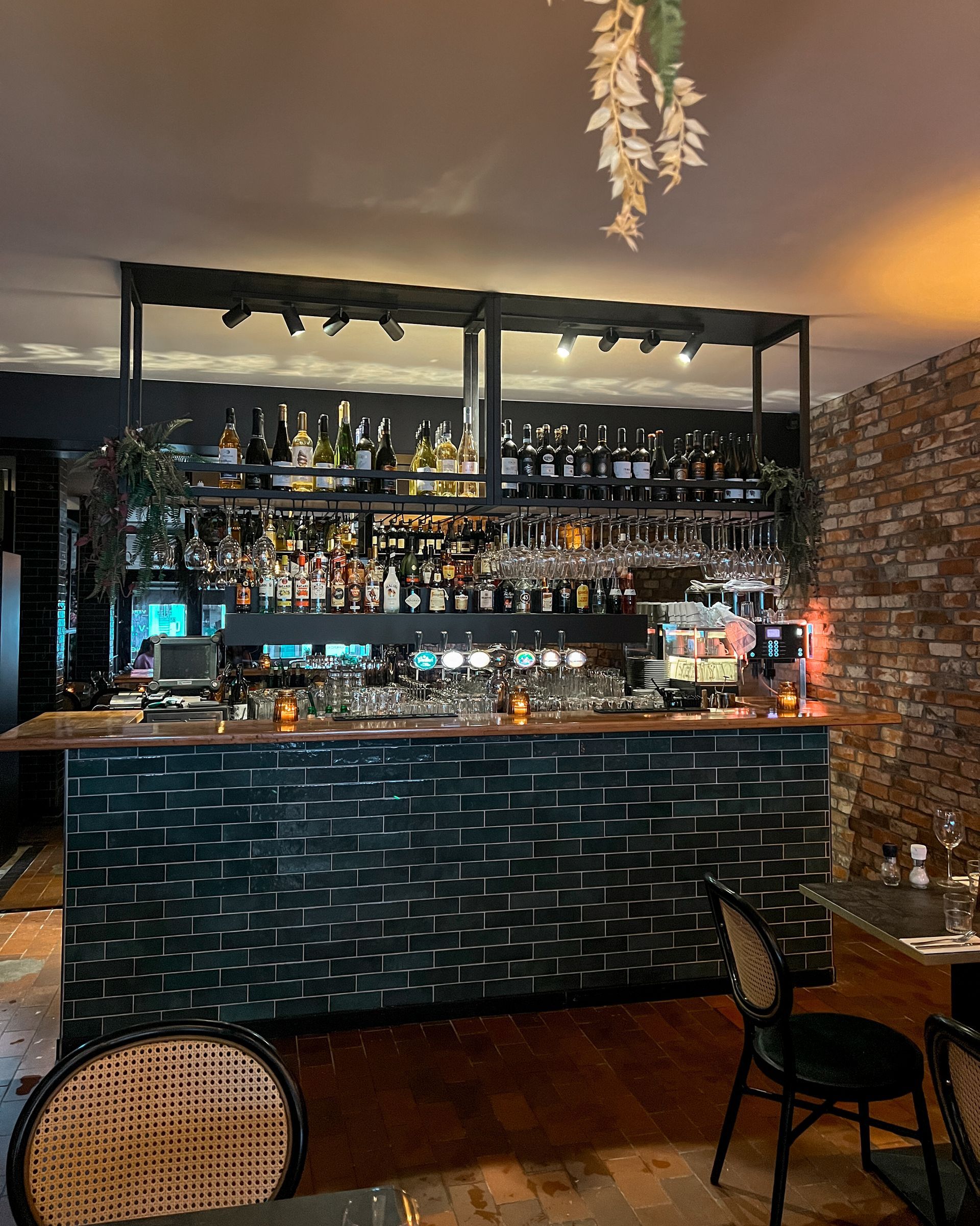 Een restaurant met een bar en tafels en stoelen.