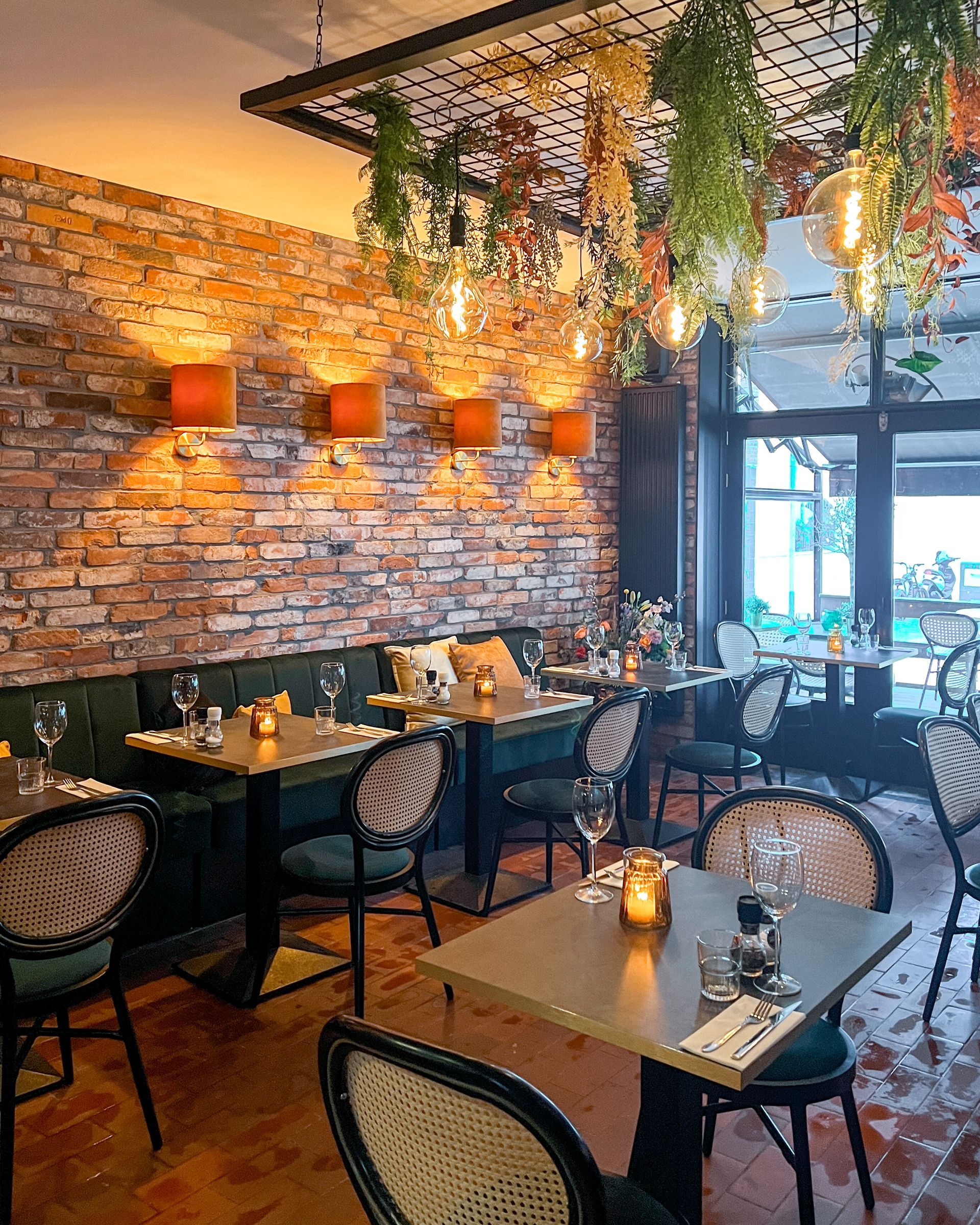 Een restaurant met tafels en stoelen en een bakstenen muur.