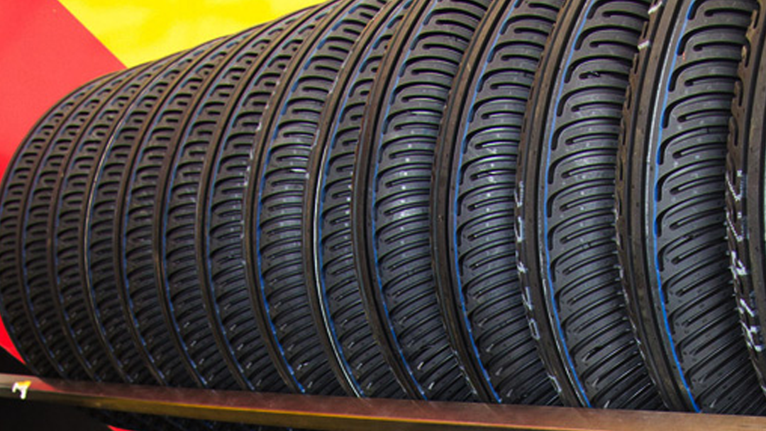 Row of black bicycle tires with curved tread pattern.