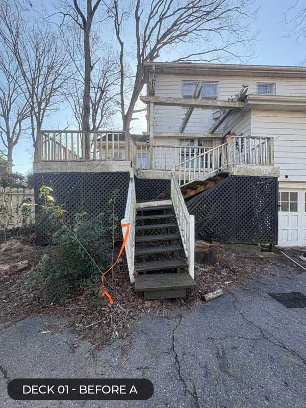 Deck with central stairs leading to a raised porch, surrounded by bare trees and lattice skirting under the deck.