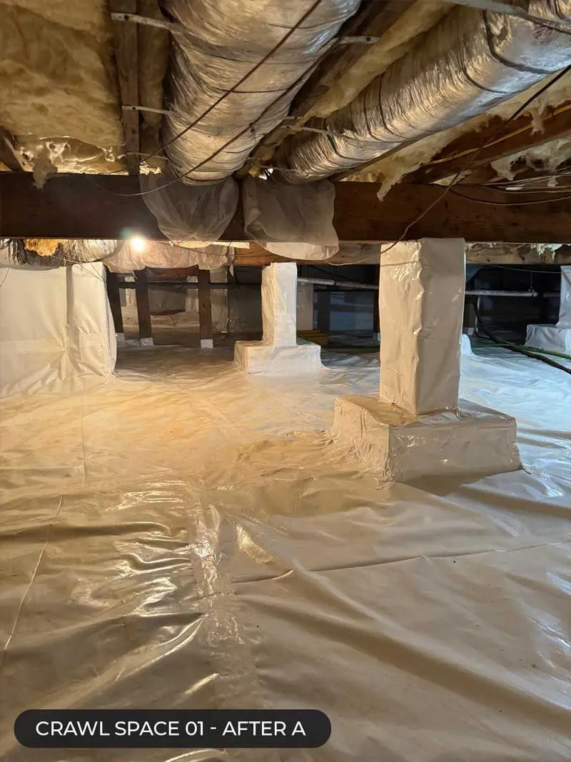 Crawlspace with insulated ductwork, white support posts, and plastic sheeting over the ground.