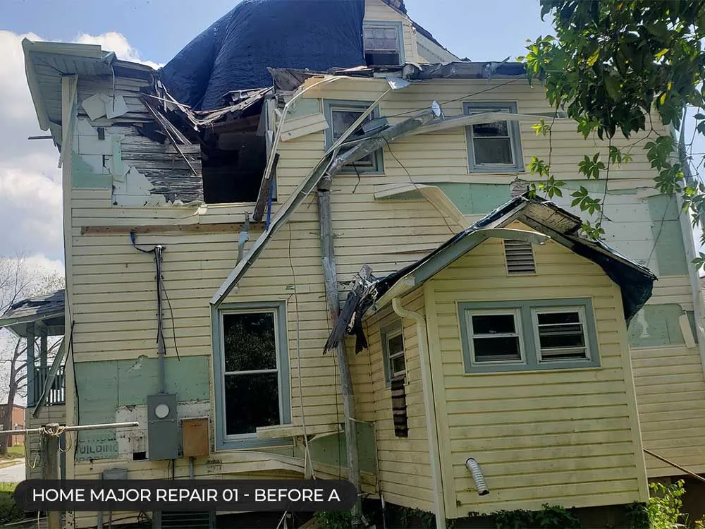 Damaged yellow house with collapsed roof and exposed interior after major repair