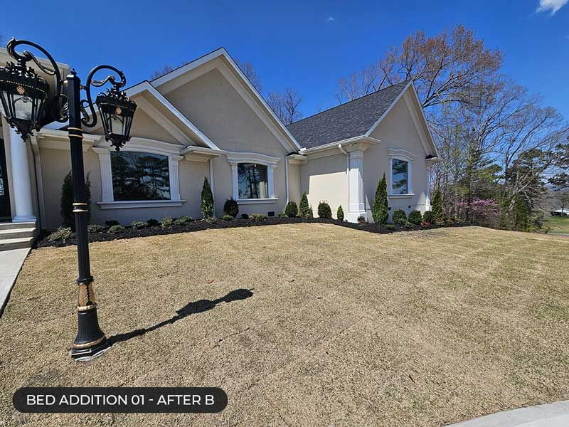 Front yard of a white house with a sloped tan lawn and black lamp post under a blue sky