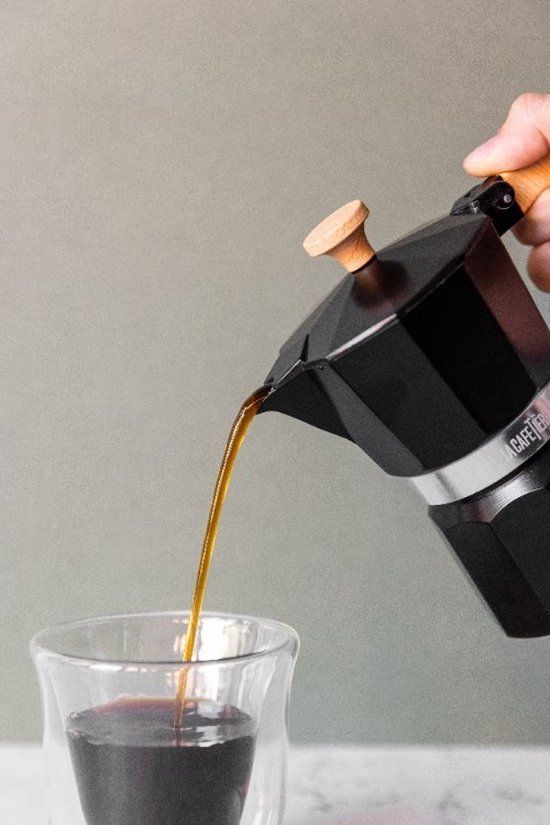 Een koffiepot en een kopje koffie staan op een rots.