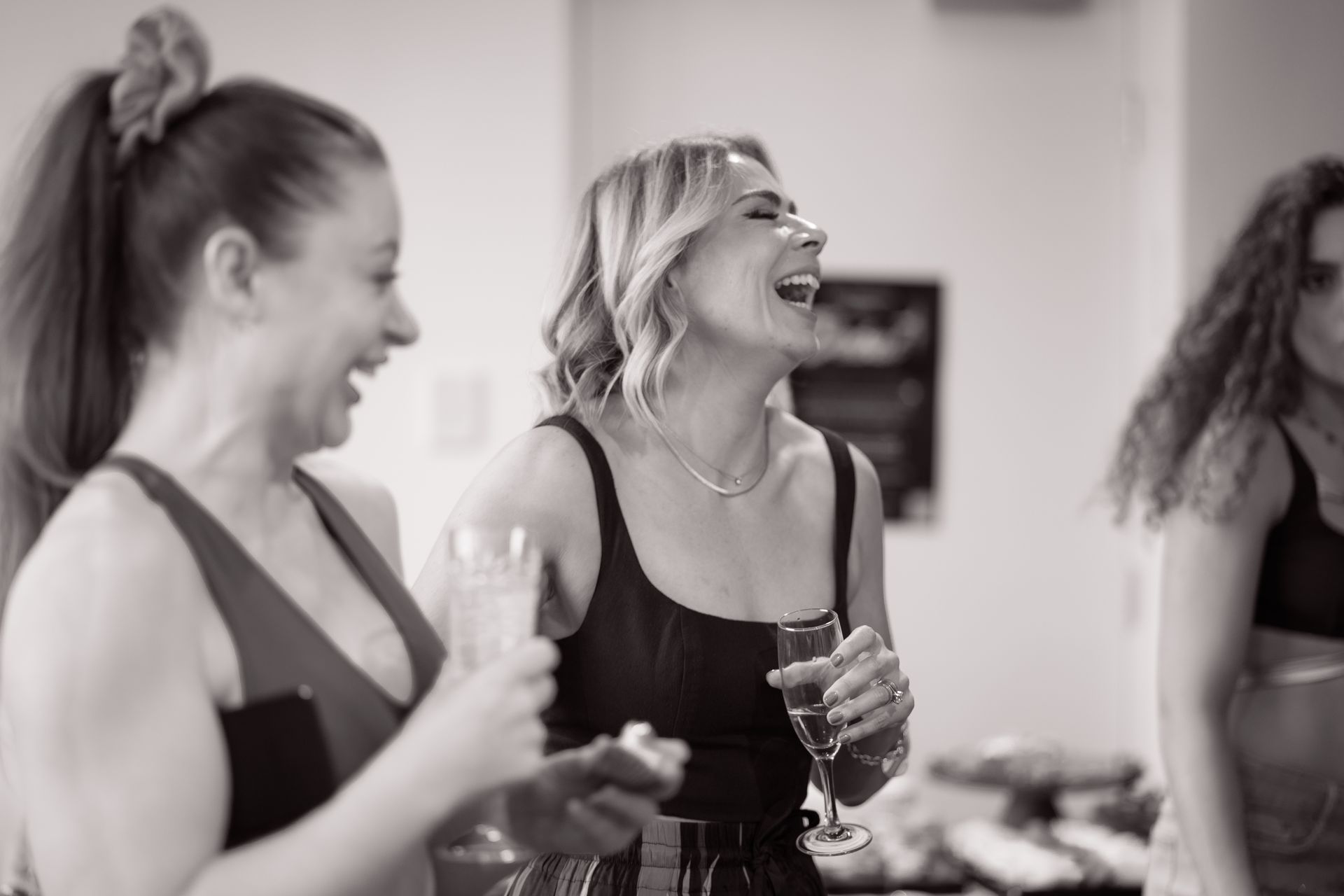 Woman with a drink laughing with friends.