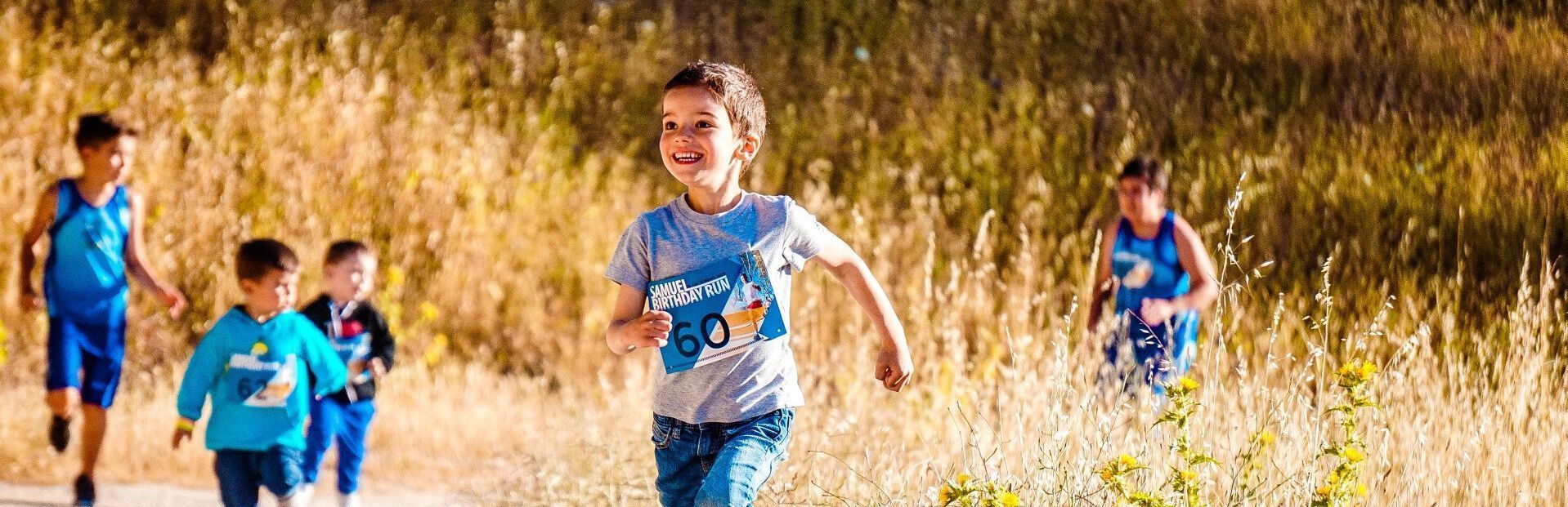 A group of children are running in a field.