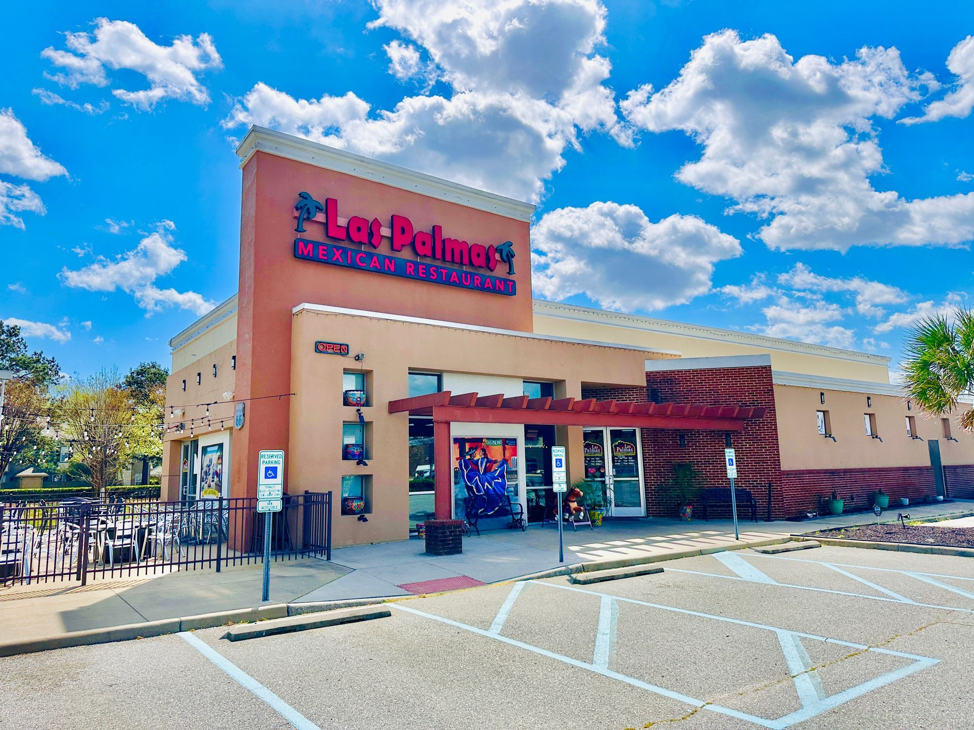 Exterior of Las Palmeras Mexican Restaurant under a partly cloudy sky.