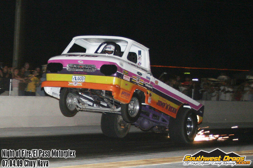 A purple and white truck is doing a trick on a race track