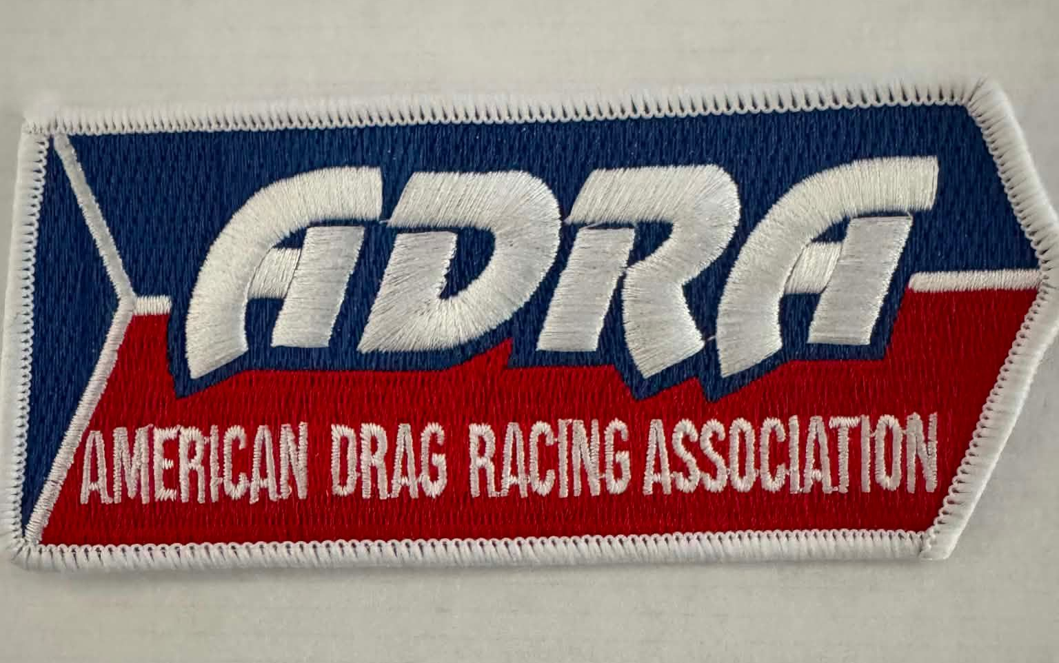 A red white and blue shield with the word adra on it