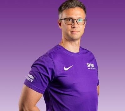 Man in paars sportshirt met bril tegen een paarse achtergrond met kleurverloop