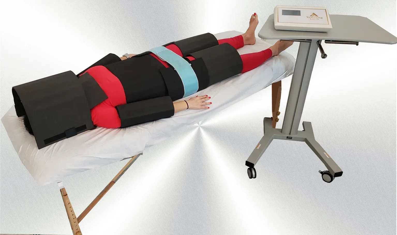 Woman receiving laser treatment on her abdomen. Practitioner in black gloves holds device.