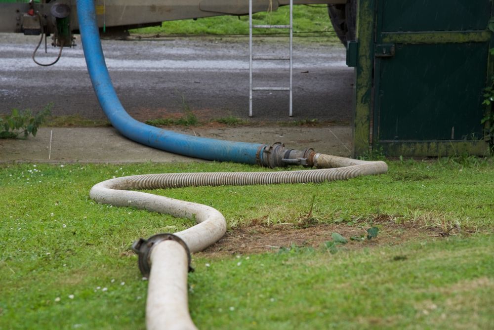 A Hose Is Connected To A Truck In A Yard — All Hours Vac Truck In Stanwell, QLD