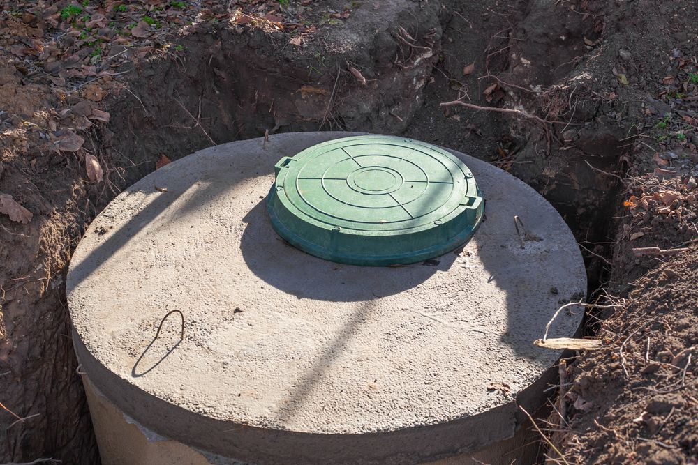 A Concrete Septic Tank With A Green Lid Is Sitting In The Dirt — All Hours Vac Truck In Yeppoon, QLD