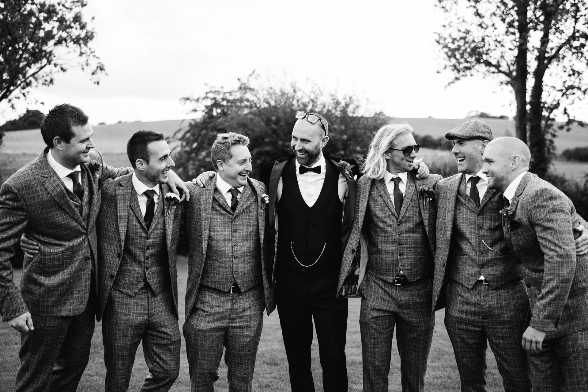 A black and white photo of a group of men in suits standing next to each other.