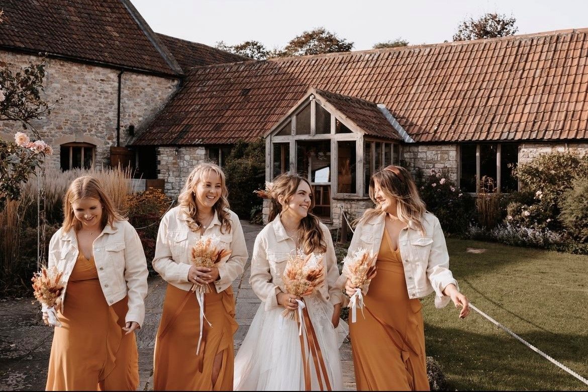 A bride and her bridesmaids are walking in front of a building.